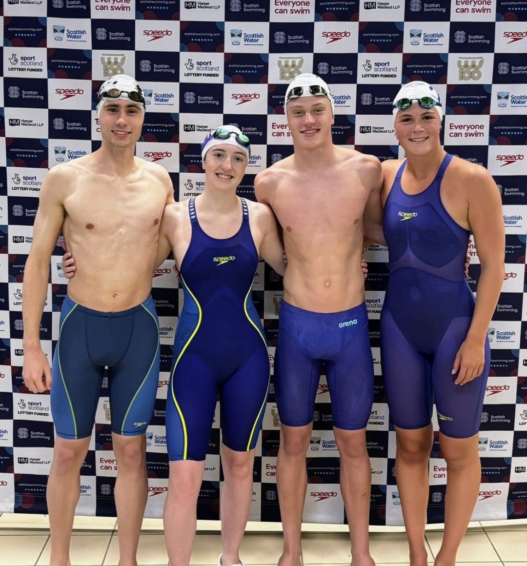 Four Monifieth swimmers together in front of a swimming event backdrop