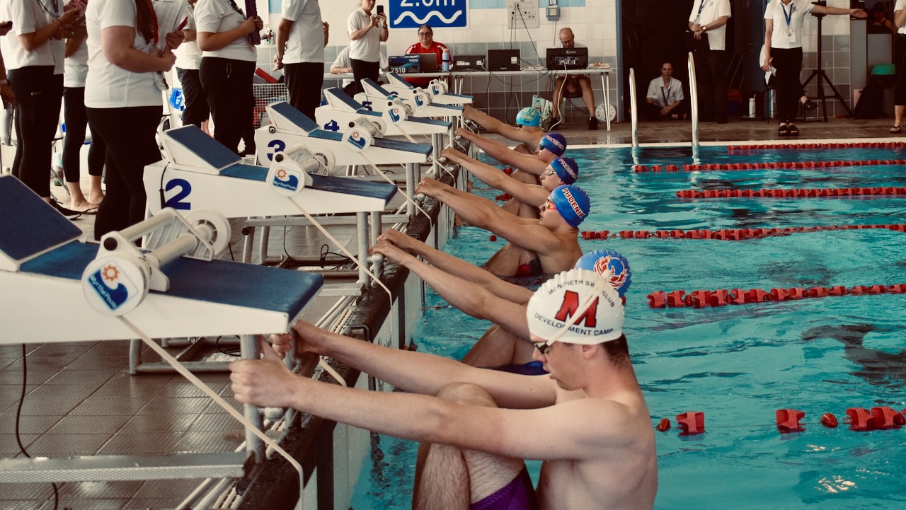 Swimmers preparing for a backstroke start
